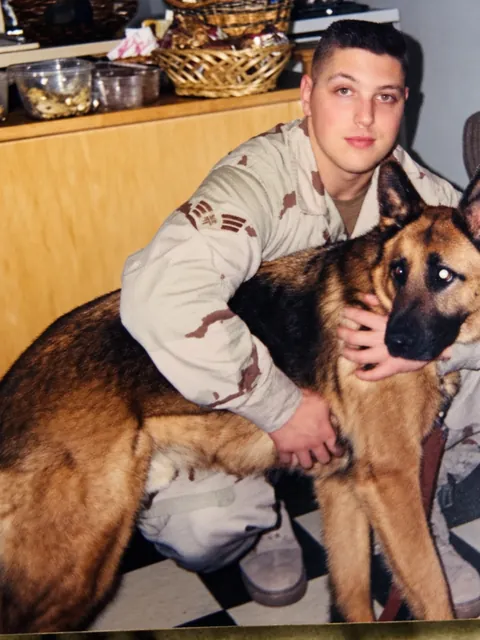 Tony Mint in military uniform with a German Shepherd